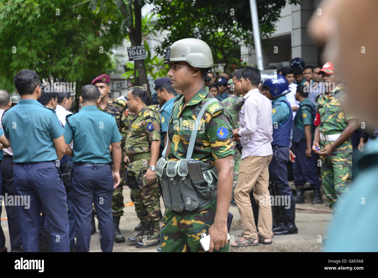 Les soldats et la police bangladaise à pied le long d'une rue menant à un restaurant de luxe à Dhaka le 2 juillet 2016, à la suite d'un siège sanglant là par des attaquants armés qui ont commencé le 1er juillet. Des militants lourdement armés ont assassiné 20 otages au Bangladesh, le hacking beaucoup de leurs victimes à la mort, avant que six des assaillants ont été abattus à la fin d'un siège le 2 juillet dans un restaurant rempli d'étrangers. Comme l'État islamique (Est) le groupe a revendiqué la responsabilité de ce carnage au début de la maison de l'Eid, Premier Ministre Sheikh Hasina a dit qu'elle était déterminée à éradiquer l'activisme musulman principalement na Banque D'Images