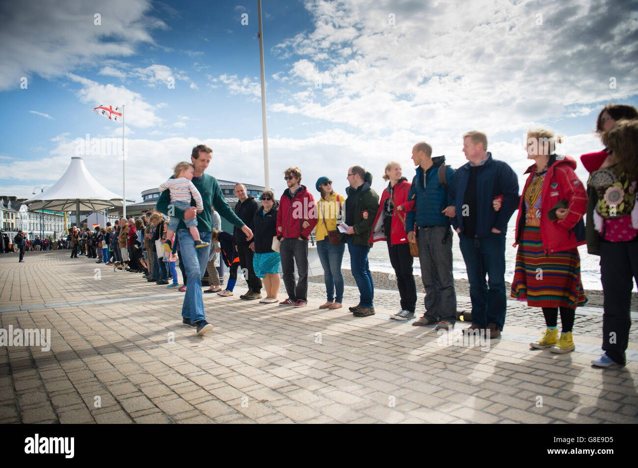 Pays de Galles Aberystwyth UK, samedi 02 juillet 2016 Plus de 300 personnes se sont rendues sur un venteux samedi après-midi pour un parti non-politique post-BREXIT protester en faveur de l'immigration et des réfugiés , à l'extérieur du kiosque sur la promenade à Aberystwyth au Pays de Galles. Après avoir entendu un certain nombre d'orateurs expriment leurs inquiétudes après le "quitter" lors du récent référendum, ils ont ensuite formé une chaîne humaine, reliant les bras le long du front de mer Photo © Keith Morris Banque D'Images