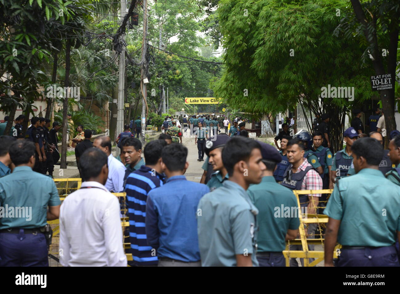 Les soldats et la police bangladaise à pied le long d'une rue menant à un restaurant de luxe à Dhaka le 2 juillet 2016, à la suite d'un siège sanglant là par des attaquants armés qui ont commencé le 1er juillet. Des militants lourdement armés ont assassiné 20 otages au Bangladesh, le hacking beaucoup de leurs victimes à la mort, avant que six des assaillants ont été abattus à la fin d'un siège le 2 juillet dans un restaurant rempli d'étrangers. Comme l'État islamique (Est) le groupe a revendiqué la responsabilité de ce carnage au début de la maison de l'Eid, Premier Ministre Sheikh Hasina a dit qu'elle était déterminée à éradiquer l'activisme musulman principalement na Banque D'Images