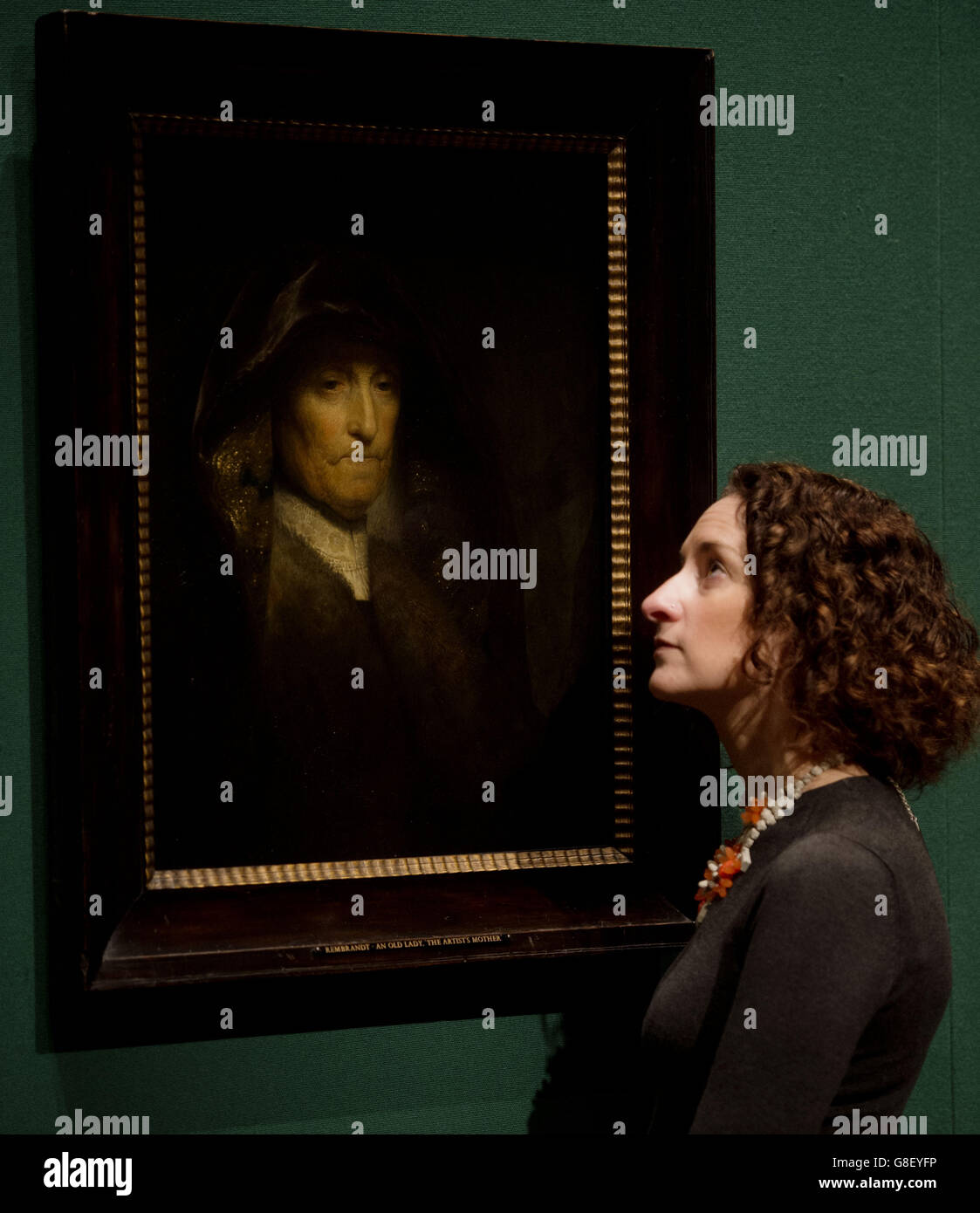 Un employé de la Royal Collection Trust voit l'œuvre « une vieille femme, appelée « la mère de l'artiste » de Rembrandt van Rijn (1627-1629) à la Queen's Gallery de Buckingham Palace, Londres. Banque D'Images