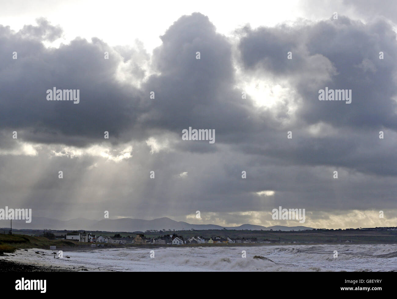 Des puits de lumière du soleil se brisent à travers les nuages au-dessus du village d'Allonby en Cumbria, alors que la queue de Storm Abigail atteint la côte. Banque D'Images