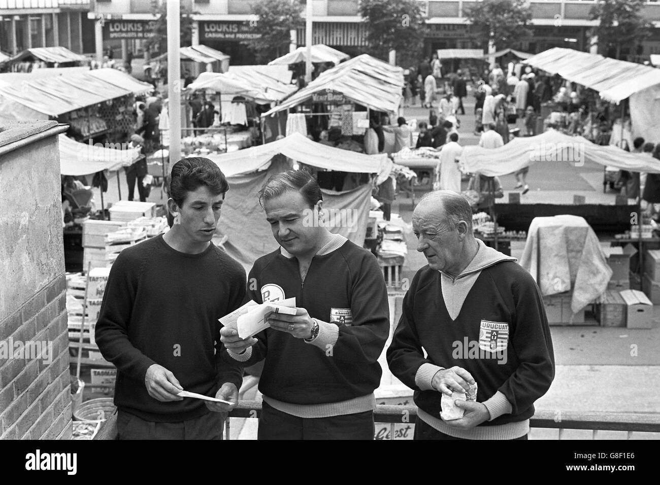 (G-D) Victor Esparrago, uruguayen, le professeur Omar Borras et José Derude examinent les cartes postales qu'ils ont achetées sur le marché lors d'un voyage shopping Banque D'Images