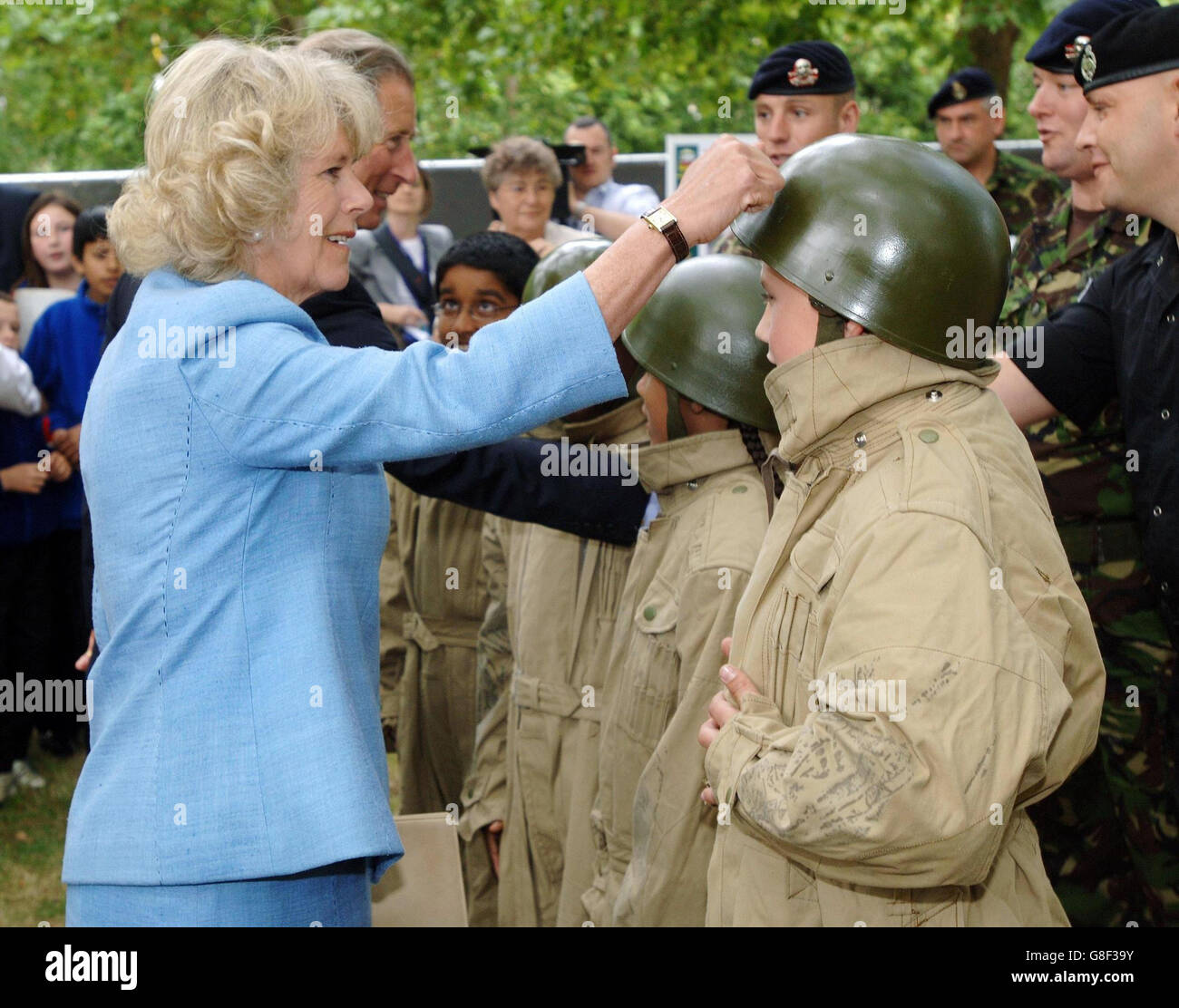 Le Prince de Galles et la Duchesse de Cornwall testent la force d'un chapeau d'étain porté par un enfant exposant à l'ouverture du Living Museum and Veterans Centre, St James' Park, Londres, où la Grande-Bretagne de guerre est mise à vie. Banque D'Images