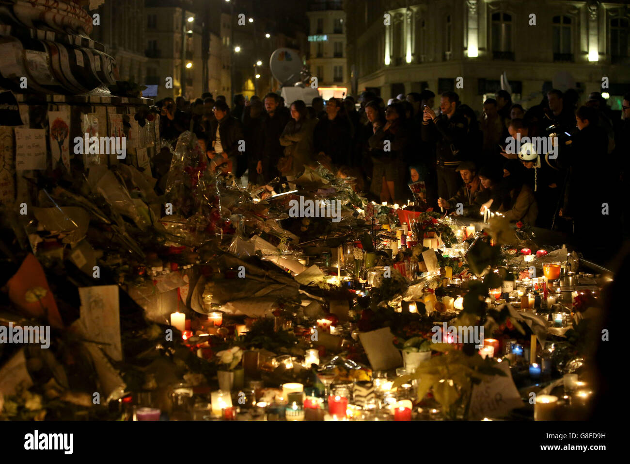 Les foules se rassemblent pour observer les hommages floraux et les bougies laissées à la place de la République, après les attaques terroristes de vendredi soir. Banque D'Images