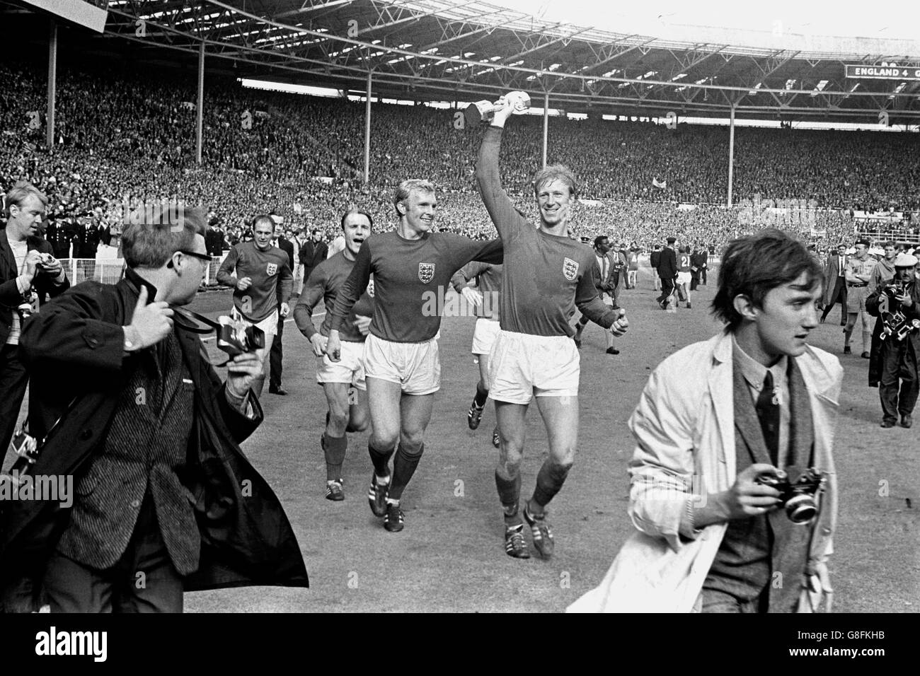 Jack Charlton (r), en Angleterre, a remporté le trophée Jules Rimet lorsqu'il le parée autour de Wembley avec ses coéquipiers Ray Wilson (l), George Cohen (deuxième l) et Bobby Moore (deuxième r) après leur victoire en 4-2 Banque D'Images