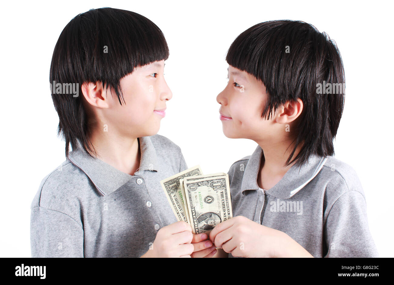 Portrait de deux garçons, des jumeaux de la détention de monnaie isolé sur blanc. Banque D'Images