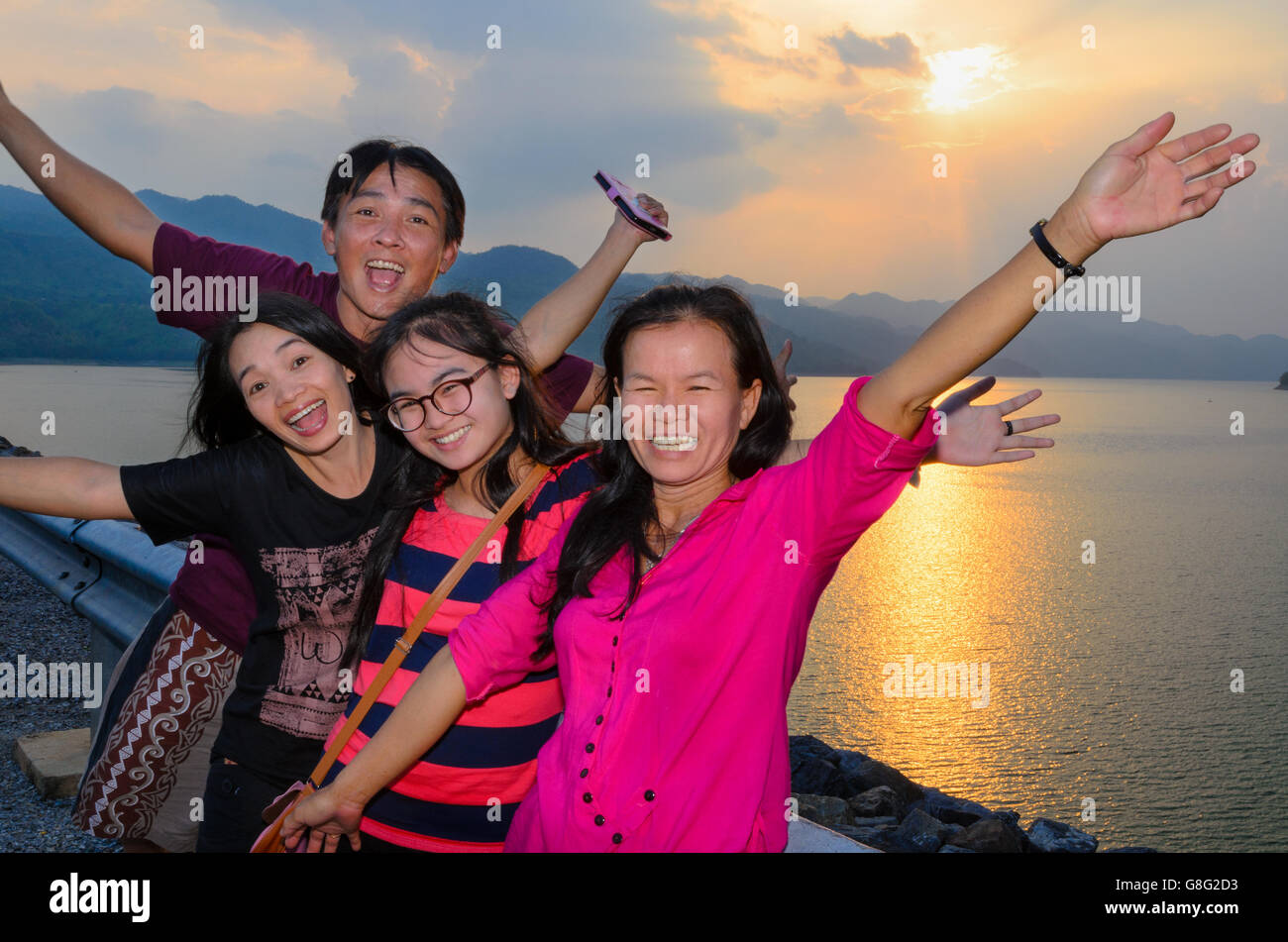 Groupe de personnes la famille les touristes asiatiques sont heureux pendant le coucher du soleil sur le lac du barrage de Khuean Sinakharin à Kanchanaburi Banque D'Images