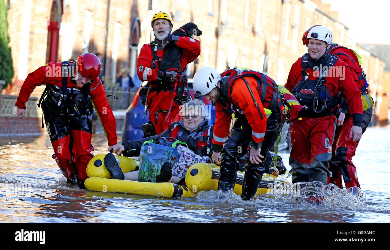 Les secouristes aident une dame et son chien à Carlisle, après une forte pluie de Storm Desmond à travers la Grande-Bretagne, en amenant de forts vents et de fortes pluies qui ont causé Cumbria à déclarer un incident majeur. Banque D'Images