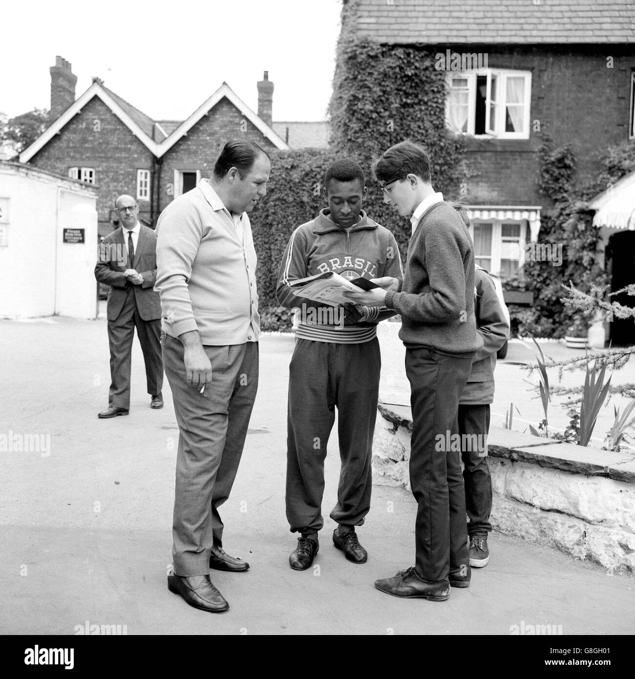 Pele (c) du Brésil, blessé et non disponible à la sélection, signe des autographes pour les jeunes fans à l'extérieur de Goodison Park comme le docteur de l'équipe Hilton Gosling (l) regarde Banque D'Images