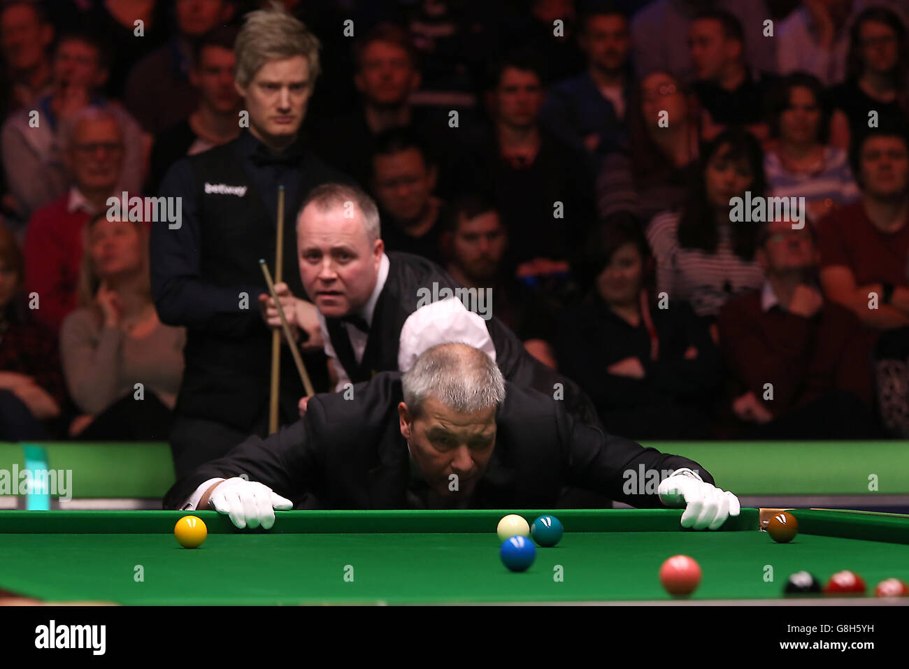 John Higgins et Neil Robertson regardent comme arbitre Jan Verhaas étudie la table pendant le dixième jour du championnat britannique de Snooker 2015 de Betway au York Barbican, York. Banque D'Images