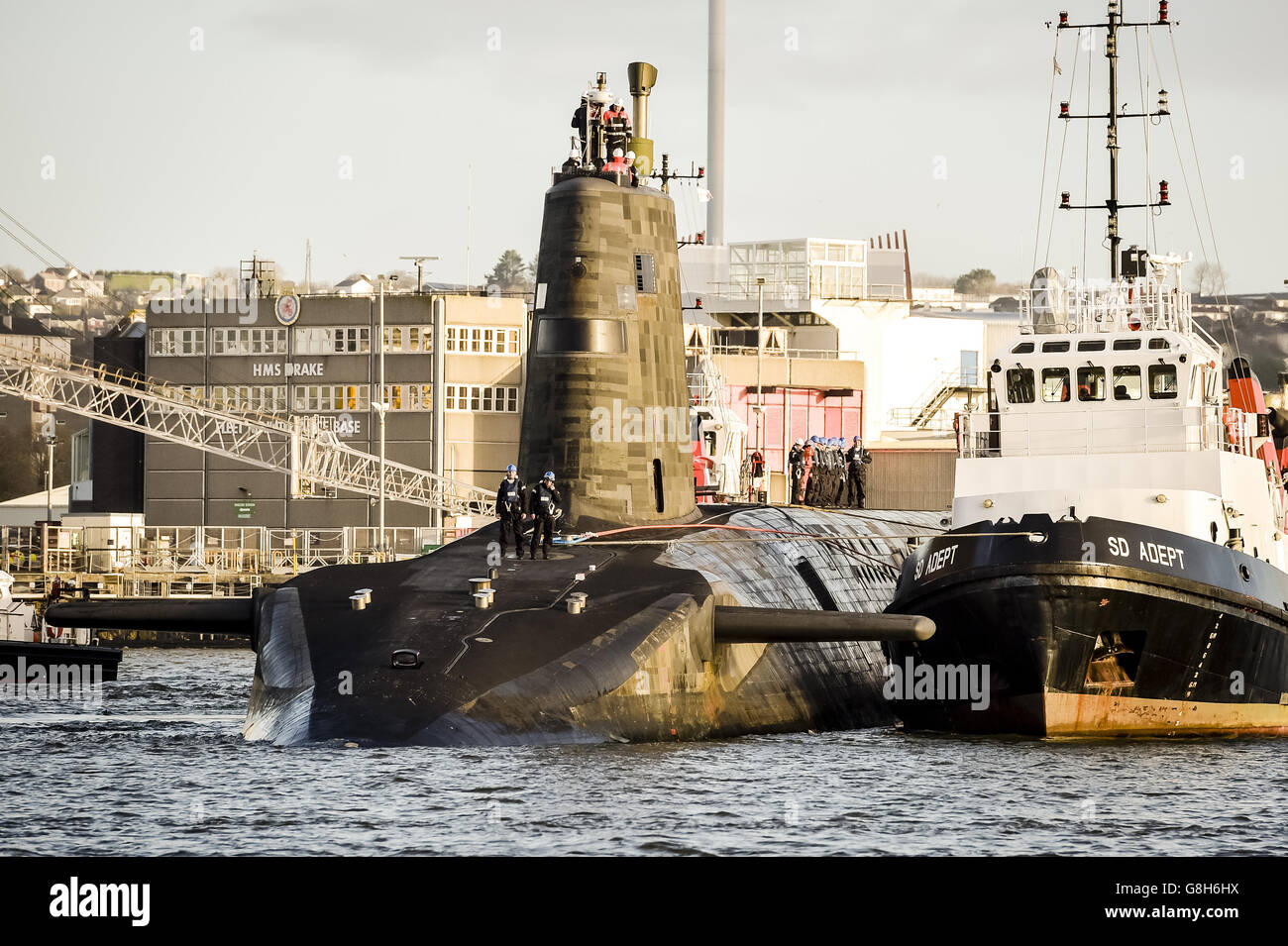 HMS Vengance à côté d'un remorqueur, alors que le sous-marin de dissuasion nucléaire britannique de classe V quitte le port de Devonport, Plymouth. Banque D'Images