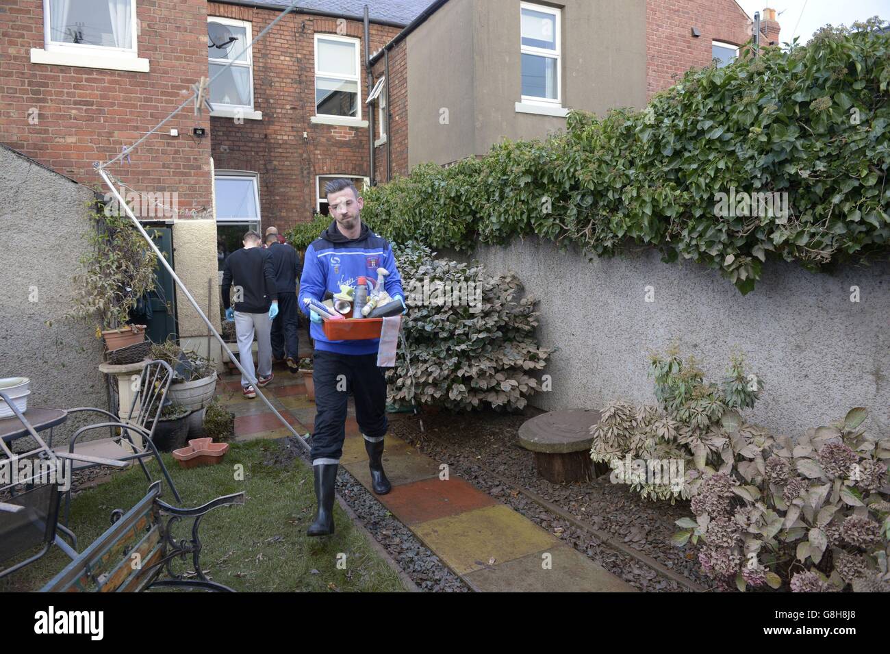 Le footballeur de Carlisle United Michael Raynes aide à nettoyer les objets d'une maison inondée de Carlisle alors que les joueurs du club ont offert de l'aide aux personnes touchées par Storm Desmond. Banque D'Images