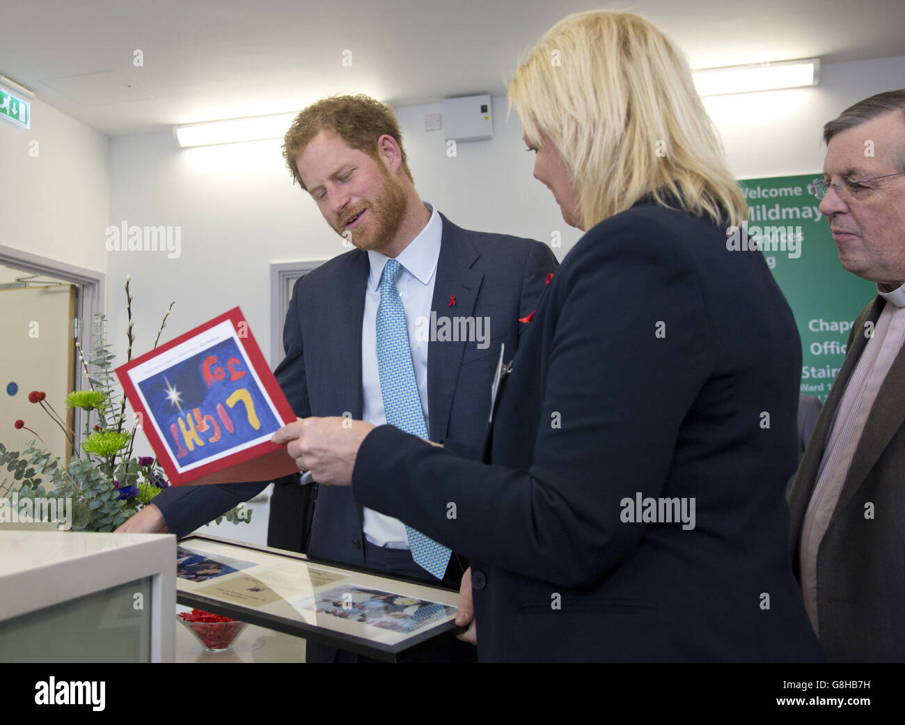 Le prince Harry reçoit une carte de Noël et des photographies encadrées de la princesse Diana lors de sa visite à l'hôpital, par Kerry Reeves-Kneip, directeur de la collecte de fonds, lors de sa visite à l'hôpital et à la charité Mildmay HIV à Londres, pour marquer l'ouverture officielle de leurs nouvelles installations spécialement construites. Banque D'Images