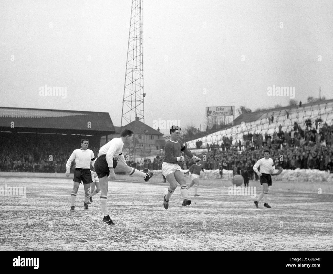 Tony Knapp, la moitié centrale de Southampton, joue le ballon devant Kinsey (à droite), l'extérieur gauche de Charlton Athletic, lors du deuxième match de la division qui a eu lieu sur le sol gelé de Charlton, dans la Valley, à Londres. Les brassards noirs des joueurs sont pour la mort de George Robinson, directeur adjoint de Charlton. Banque D'Images