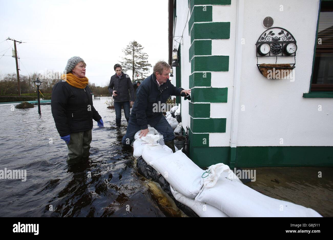 RETRANSMET LA POSITION DE CORRECTION DE CARRICK SUR SHANNON À CARRICKOBRIEN. Gertie Dunning montre Taoiseach Enda Kenny autour de sa maison après des inondations à Carrickobrien, Irlande. Banque D'Images