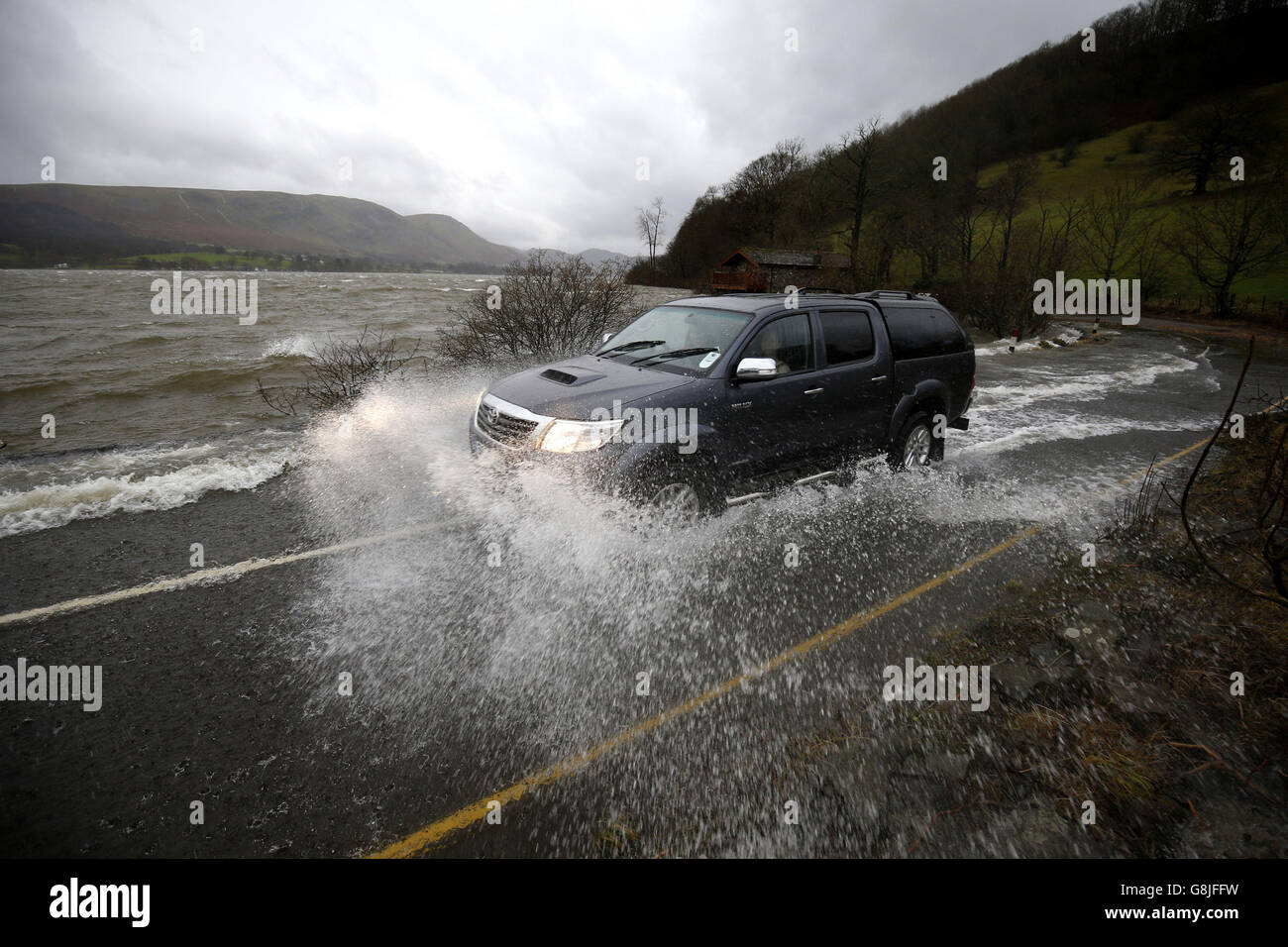 L'eau issue des inondations d'Ullswater traverse l'A592 à Cumbria, à la suite de fortes pluies, alors que Storm Frank commençait à frapper le Royaume-Uni sur le chemin des zones frappées par les inondations. Banque D'Images