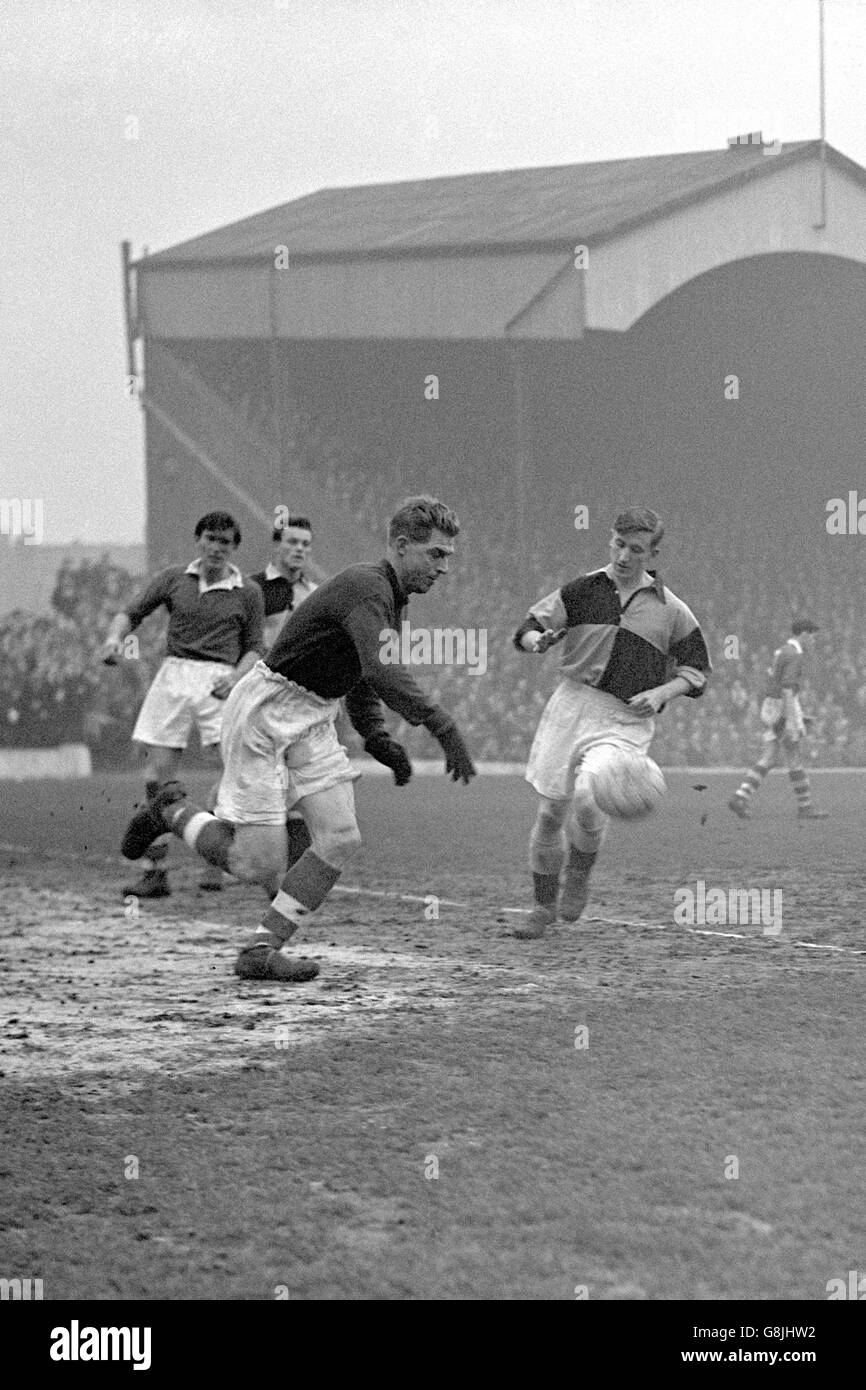 Le gardien de but de Charlton Athletic Sam Bartram (c) rebondit le ballon après avoir fait une sauvegarde, regardé par Burton Albion Giles (r) et son coéquipier Derek Ufton (l) Banque D'Images