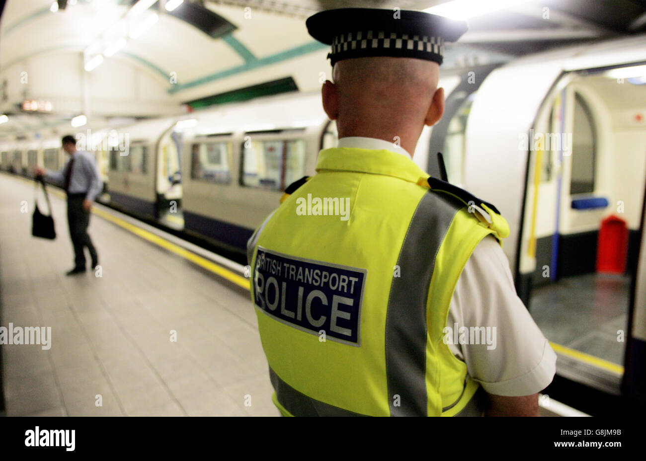 Un policier surveille un train à la station de métro Russell Square, qui a rouvert quatre semaines au jour le jour depuis l'attentat-suicide à la bombe de Londres. Banque D'Images