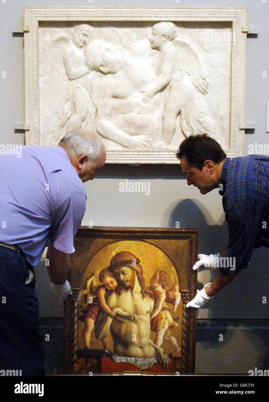 Le « Christ mort soutenu par deux Anges » de Crivelli est mis en place à côté du relief en marbre de Donatello « Christ mort entretenu par des Anges » qui a inspiré la peinture. Banque D'Images