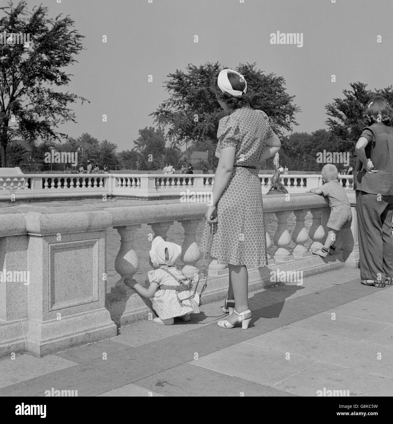 Faisceau femme tenant sangle pour éviter de se perdre l'enfant au parc, Detroit, Michigan, USA, Arthur S. Siegel pour Office of War Information, Juillet 1942 Banque D'Images