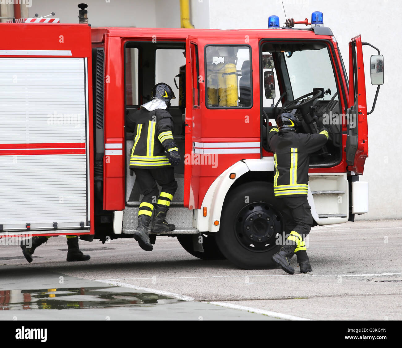 Fire Engine transportant deux pompiers et l'équipement de lutte contre l'incendie Banque D'Images