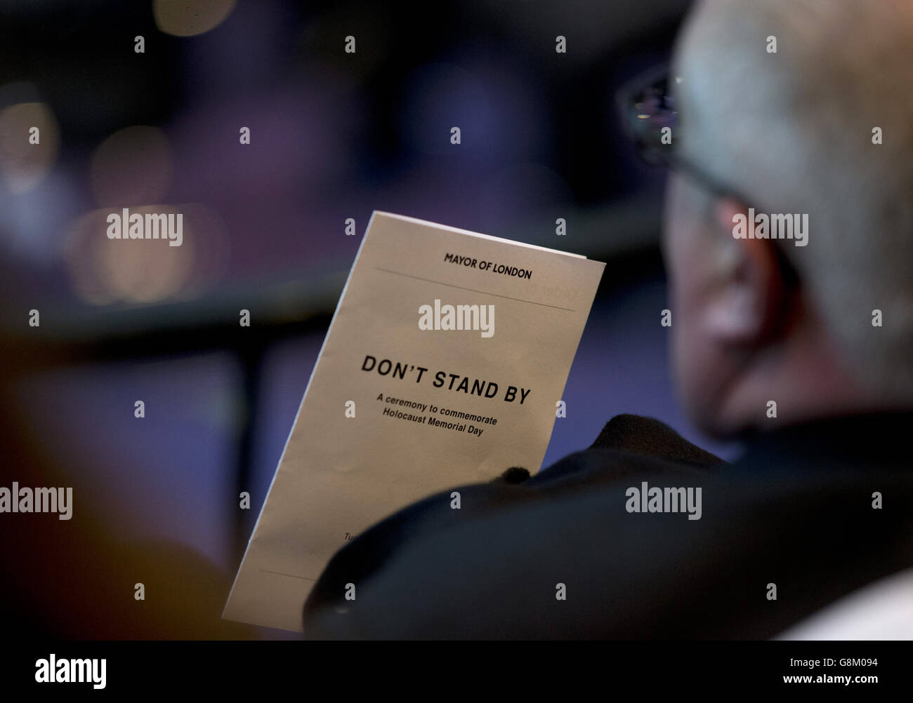 Un invité qui tient un programme lors d'une cérémonie du jour commémoratif de l'Holocauste, dans la Chambre de l'hôtel de ville de Londres. Banque D'Images