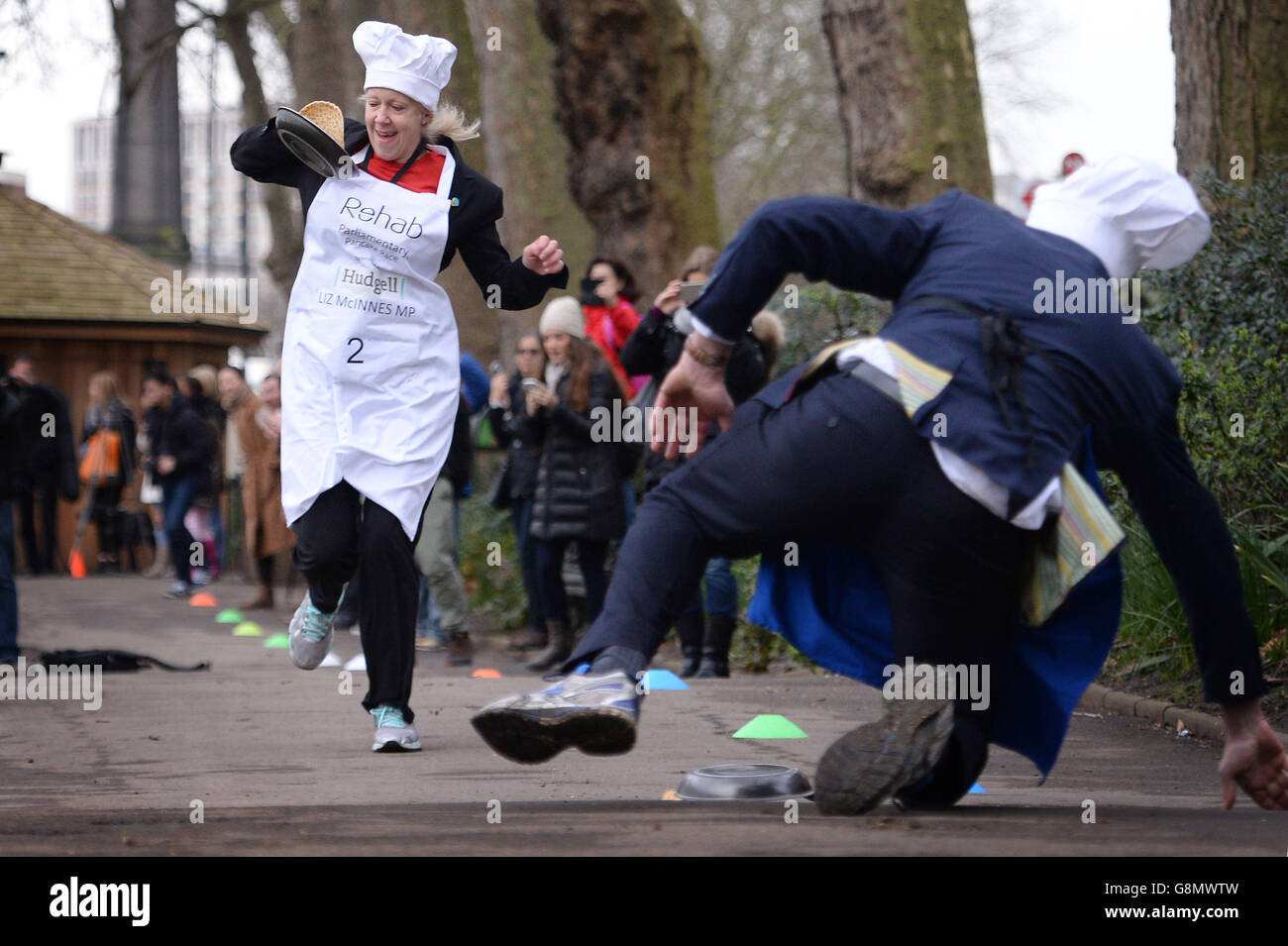 Le député de Heywood et de Middleton Liz McInnes passe devant Lord St John de Bletso et participe à la course parlementaire annuelle de Pancake Rehab dans laquelle les députés, les lords et les membres des médias se font la course le jour de la pancake pour recueillir de l'argent pour l'organisme de bienfaisance Rehab, à Victoria Tower Gardens, à Londres. Banque D'Images