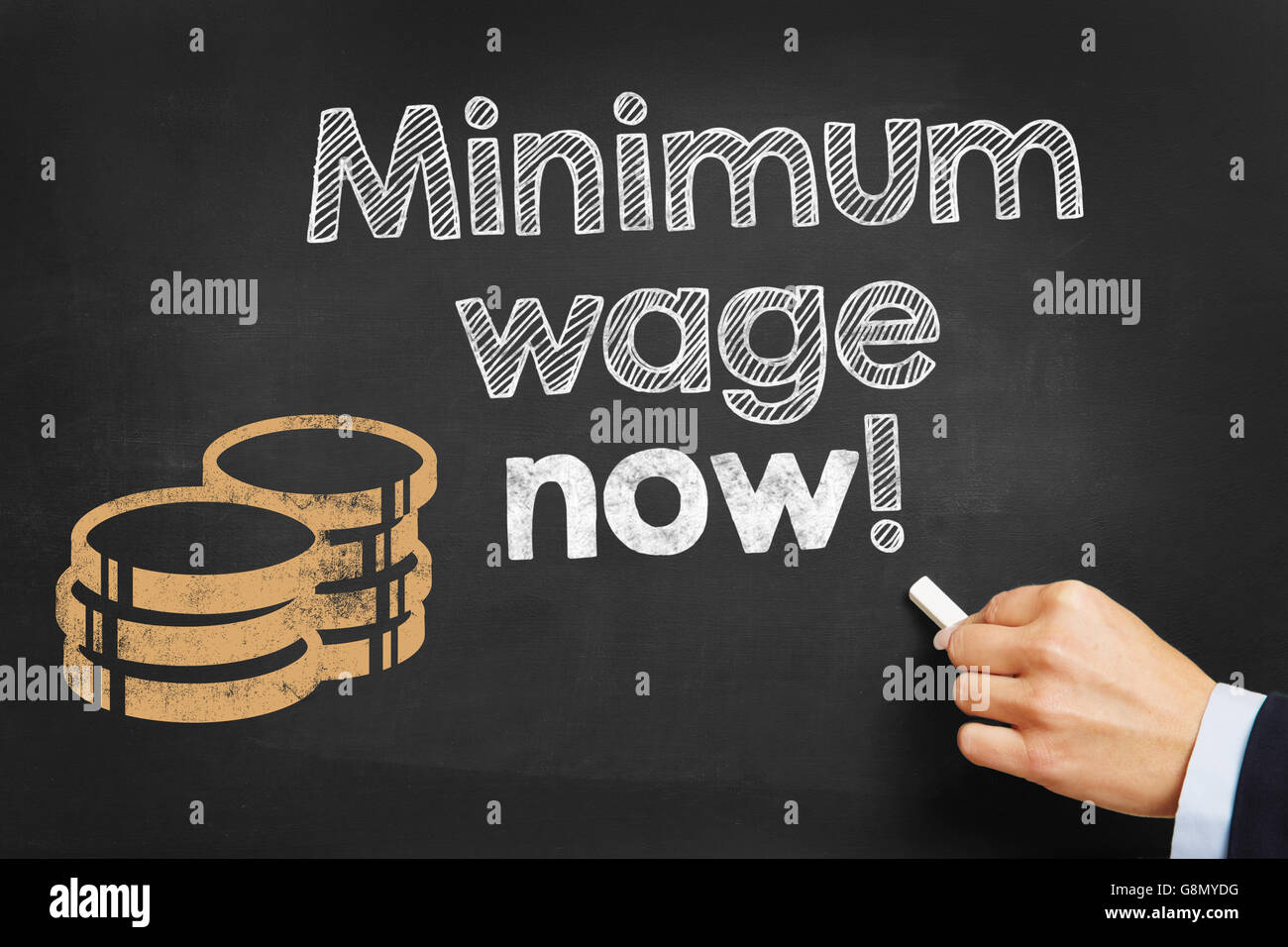 Salaire minimum écrit main maintenant !' sur tableau noir Banque D'Images