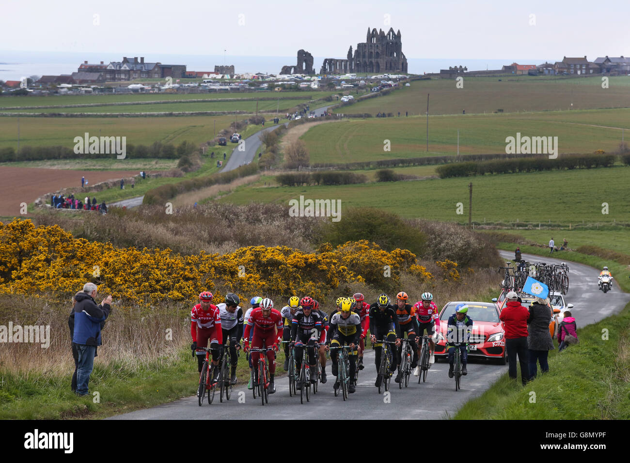 Whitby, UK. Le peloton, avec la célèbre abbaye derrière eux, en fait c'est sortir de Whitby au cours de la troisième et dernière étape de la Banque D'Images