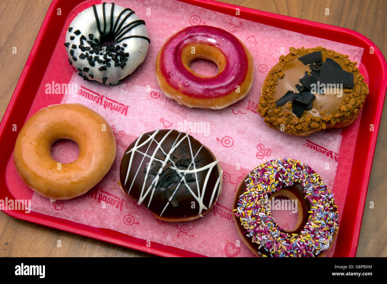 Sélection de Krispy Kreme Donuts avec divers revêtements doux. un dessert sucré desserts UK confiserie gâteaux gâteau donut Banque D'Images