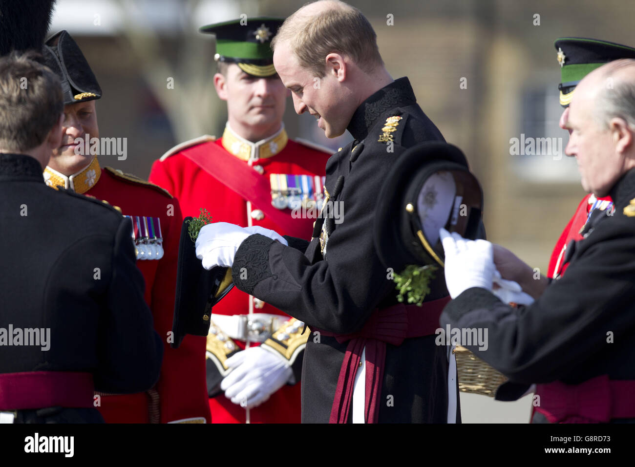Le duc de Cambridge attache une branche de shamrock à son chapeau alors qu'il présente les gardes irlandais avec des shamrocks lors d'une visite à la caserne de Cavalry à Hounslow, dans l'ouest de Londres, pour la parade de la Saint Patrick du régiment. Banque D'Images
