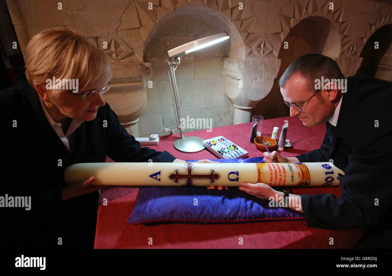 Canterbury Cathedral Virgers (orthographe traditionnelle de la cathédrale de Canterbury) Jocelyn Prebble et Mark Thompson ajoutent les dernières touches à la conception d'une bougie Pascal qui est allumée pendant la veille de Pâques et représente la figure du Christ. Banque D'Images