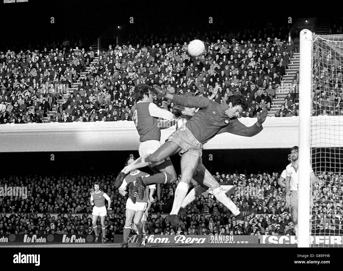 Malcolm Macdonald, attaquant de l'arsenal (à gauche), et Mervyn Day, gardien de but de West Ham, sautent pour une balle haute lors du match de la première division de Londres à Highbury. Banque D'Images