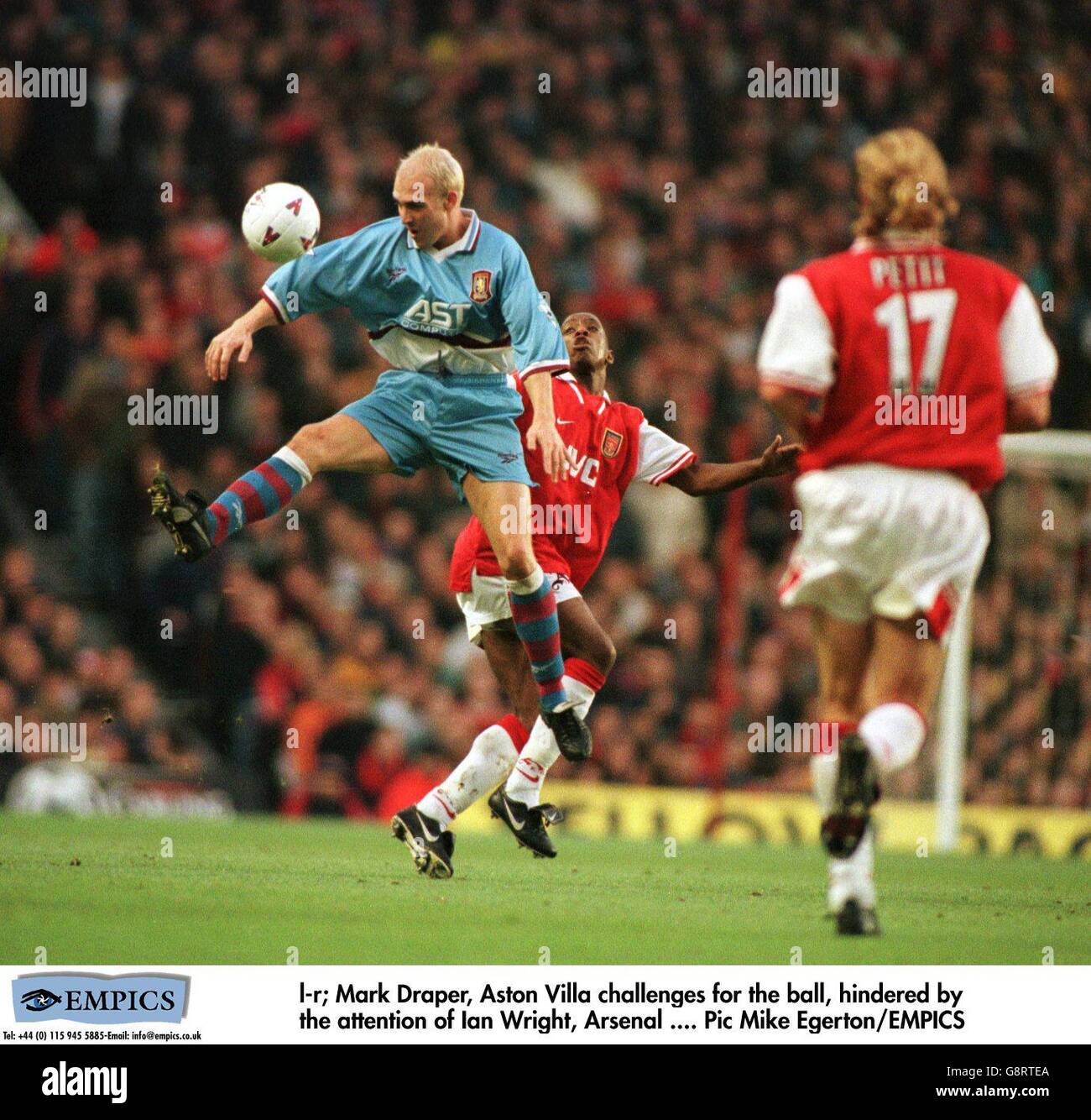 Mark Draper de Aston Villa (à gauche) saute devant Ian Wright d'Arsenal (au centre) pour gagner le ballon Banque D'Images