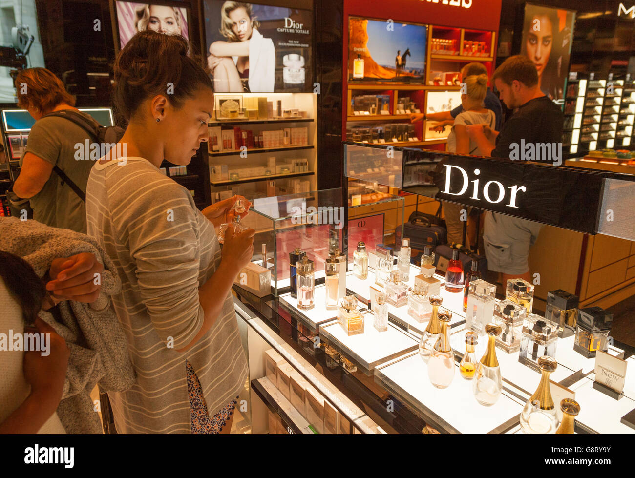 Une jeune femme magasiner pour le parfum Dior dans la boutique Duty Free de l'aéroport de Palma, Majorque Espagne Europe Banque D'Images