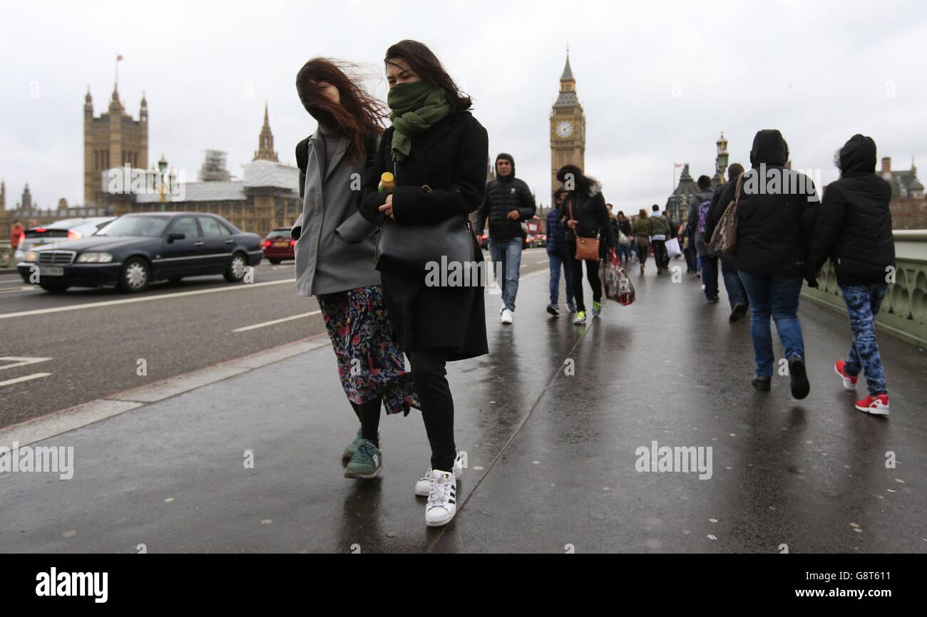 Les visiteurs du pont de Westminster, Londres, se battent contre les vents violents. La Grande-Bretagne est sur le point d'être battue par une tempête qui va provoquer de forts vents et la menace de perturbations à la fin du week-end de Pâques. Banque D'Images