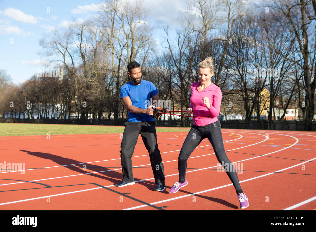 Coach et la femme à l'aide de cordes en terrain de sport de l'exercice Banque D'Images