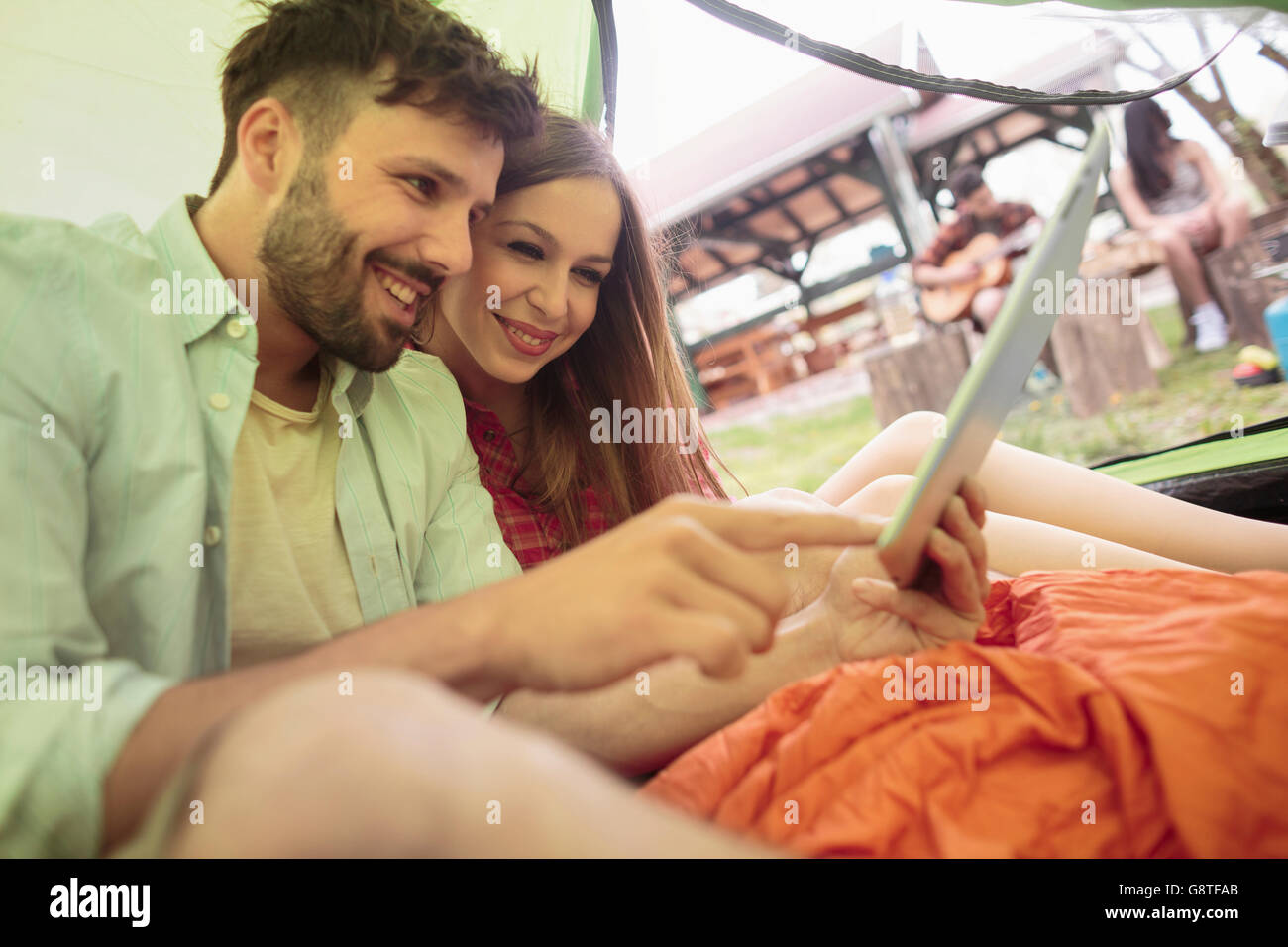 Jeune couple de camping using digital tablet Banque D'Images