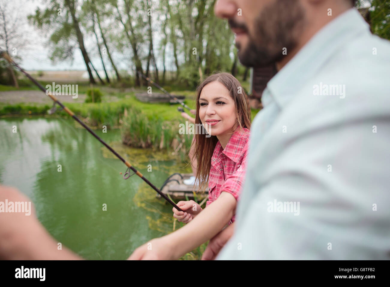 Jeune couple pêche ensemble dans le lac Banque D'Images