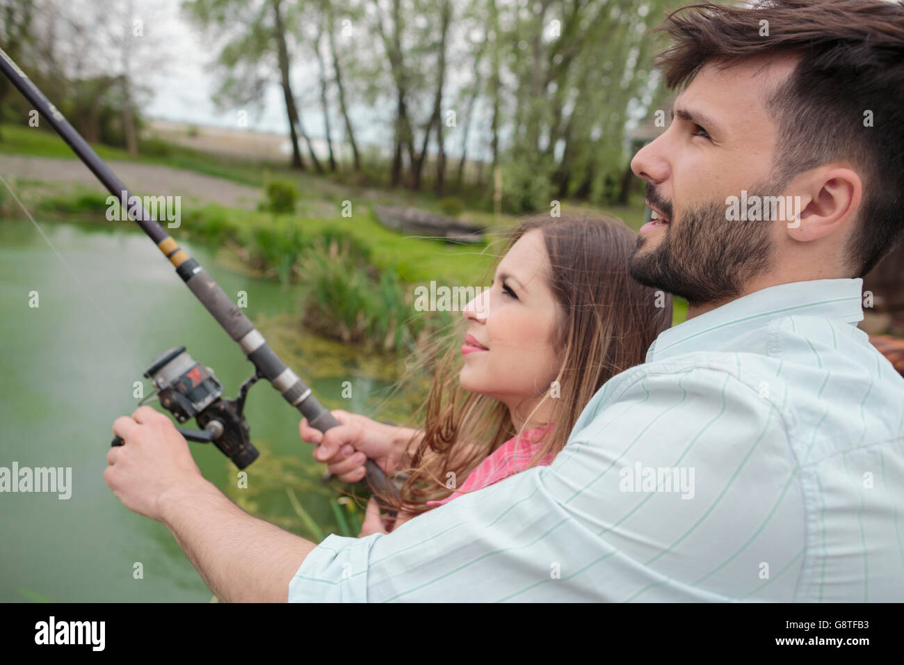 Jeune couple pêche ensemble dans le lac Banque D'Images