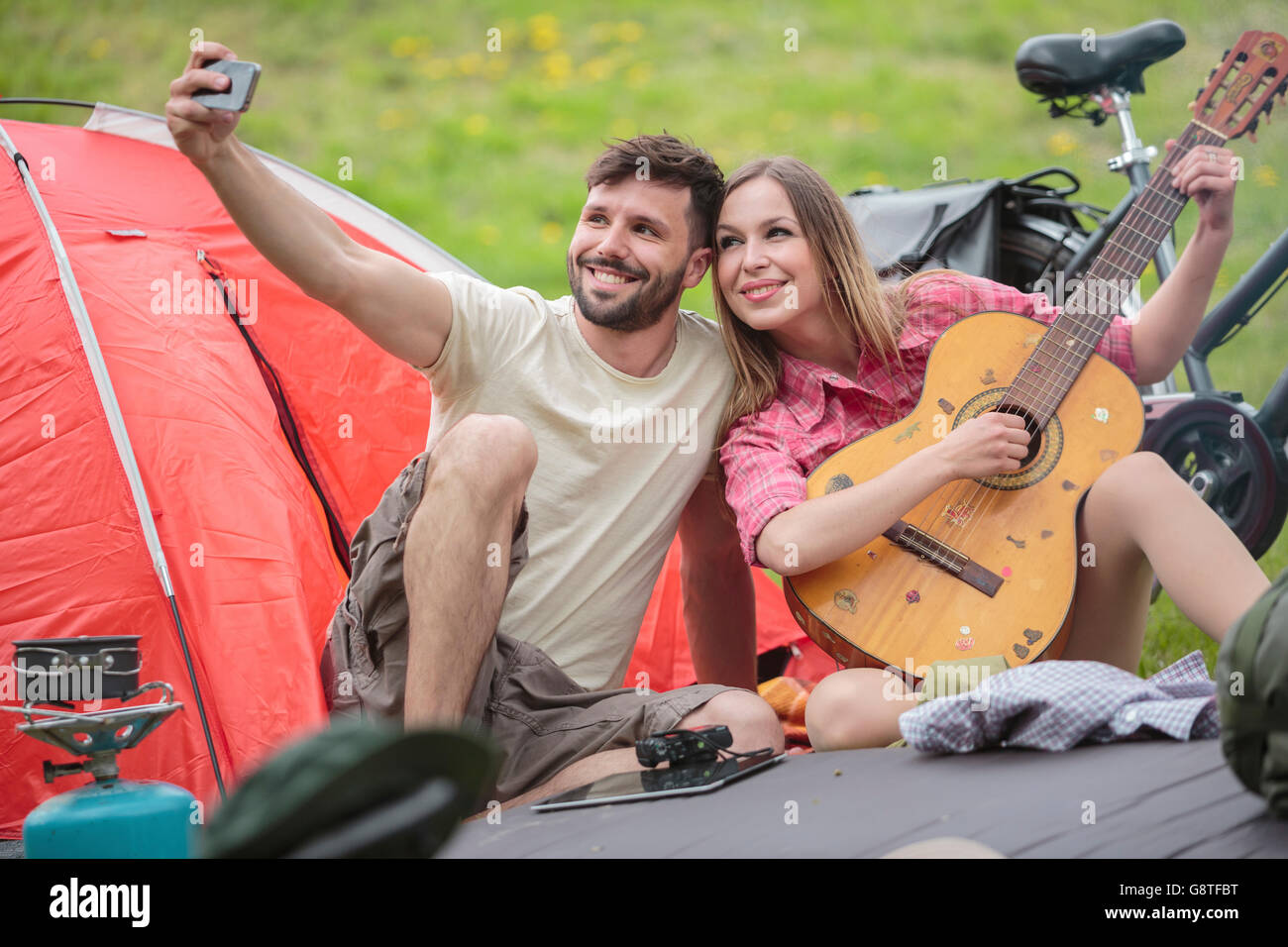 Jeune couple de camping en tenant selfies Banque D'Images