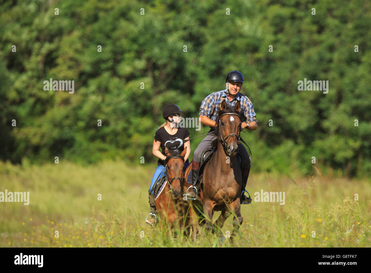 Couple l'équitation dans le champ Banque D'Images