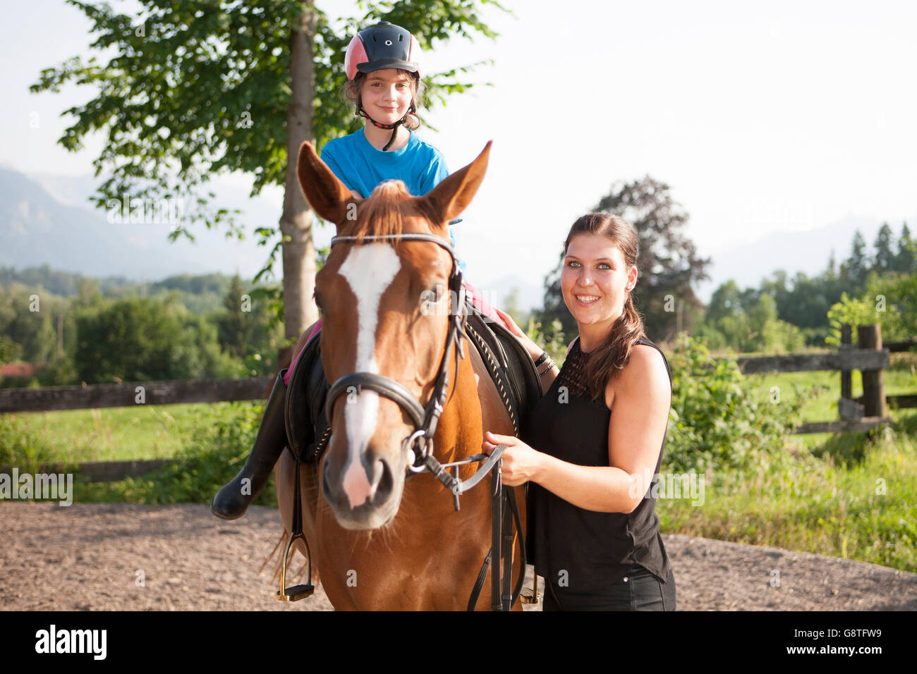 Fille apprend à monter à cheval avec l'aide de l'instructeur féminin Banque D'Images