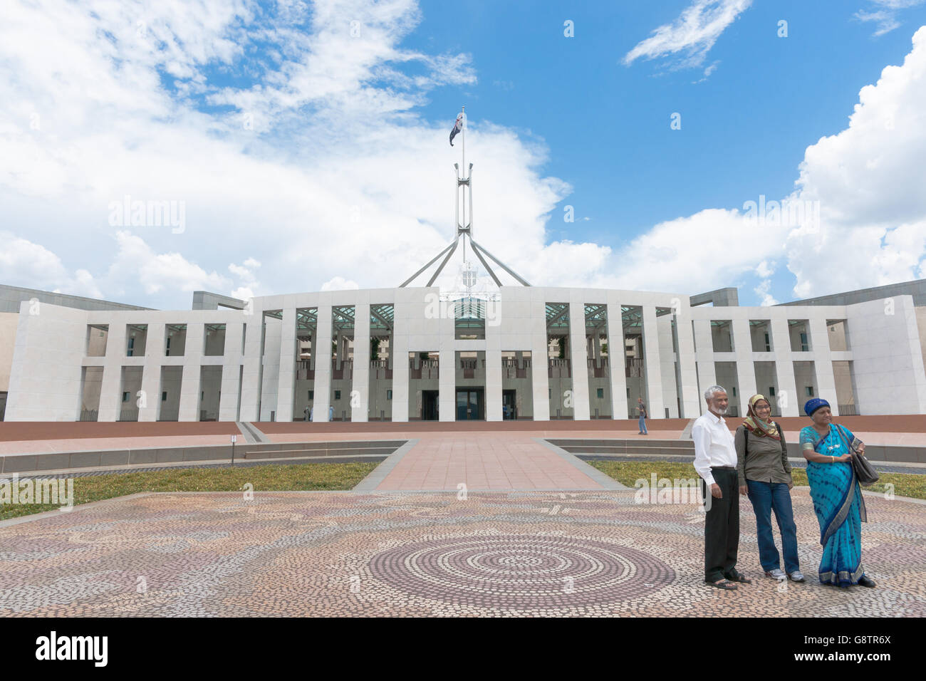 Trois touristes asiatiques posent pour la photo à l'extérieur de la Maison du parlement australien à Canberra. Banque D'Images