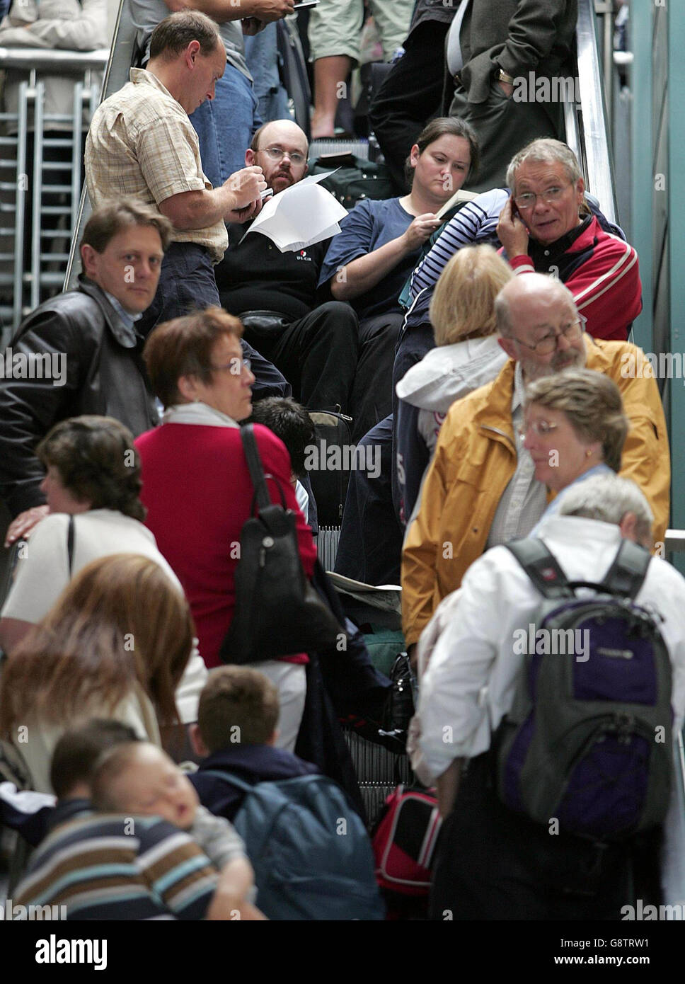 Les passagers font la queue sur les escaliers mécaniques pour se rendre dans le terminal 1 de l'aéroport de Manchester, le vendredi 23 septembre 2005, où un homme a été arrêté en vertu de la loi sur le terrorisme après avoir été vu agir de manière suspecte près d'un avion à l'aéroport. La police a utilisé un pistolet à bande pour apaiser le suspect lors d'une lutte sur le tablier près du terminal 2. Des experts en élimination de bombes ont été appelés à examiner un paquet suspect sur les lieux après l'arrestation. Voir PA Story POLICE Airport. APPUYEZ SUR ASSOCIATION photo. Le crédit photo devrait se lire: Martin Rickett/PA Banque D'Images