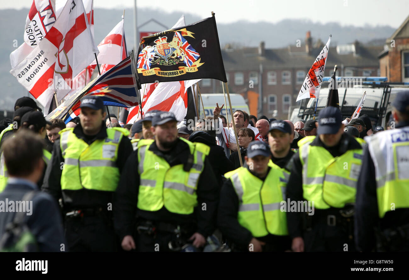 Une ligne d'officiers de police devant un groupe de manifestants d'extrême-droite à Douvres, dans le Kent, qui protestent contre l'arrivée d'immigrants; le réseau antiracisme de Kent a également organisé une contre-manifestation. Banque D'Images