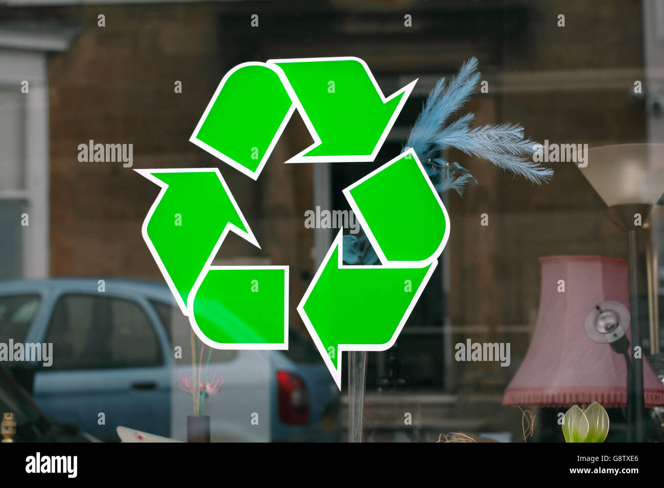 Signe de recyclage dans la fenêtre d'une boutique vendant des biens d'occasion. Banque D'Images