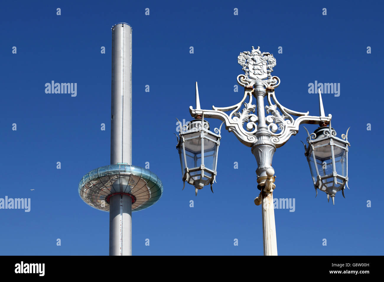 Styles de conception contrastés sur le front de mer de Brighton : le nouveau téléphérique vertical i360 et un lampadaire. Banque D'Images