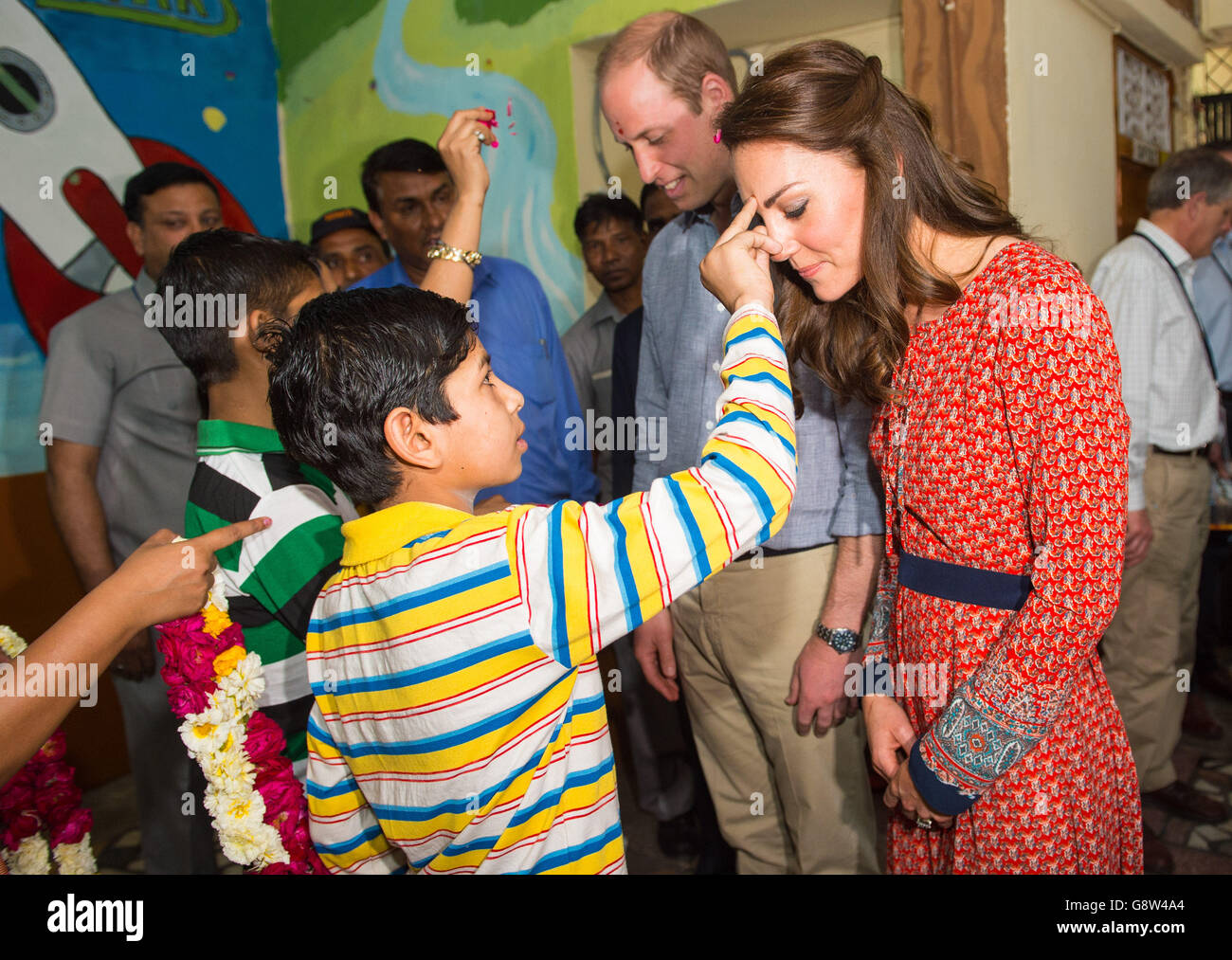 Le duc et la duchesse de Cambridge sont accueillis par un tilak au centre pour enfants dirigé par l'organisme caritatif Salaam Baalak, qui fournit une aide d'urgence et un soutien à long terme aux enfants sans abri à la gare de New Delhi, le troisième jour de la visite royale en Inde et au Bhoutan. Banque D'Images