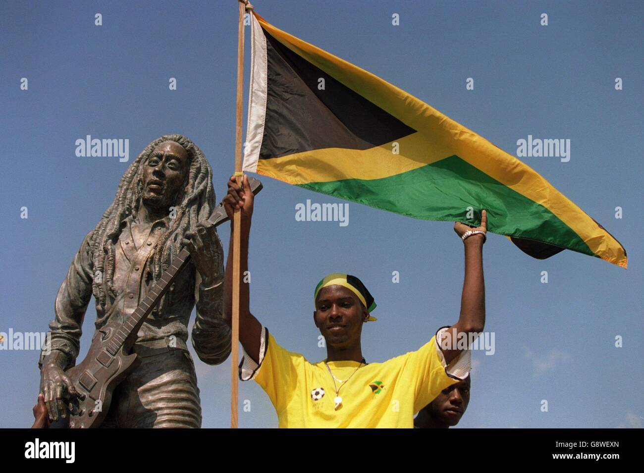 Football - qualificatif de coupe du monde - Jamaïque / Mexique.Un fan de la Jamaïque se tient devant une statue de Bob Marley Banque D'Images